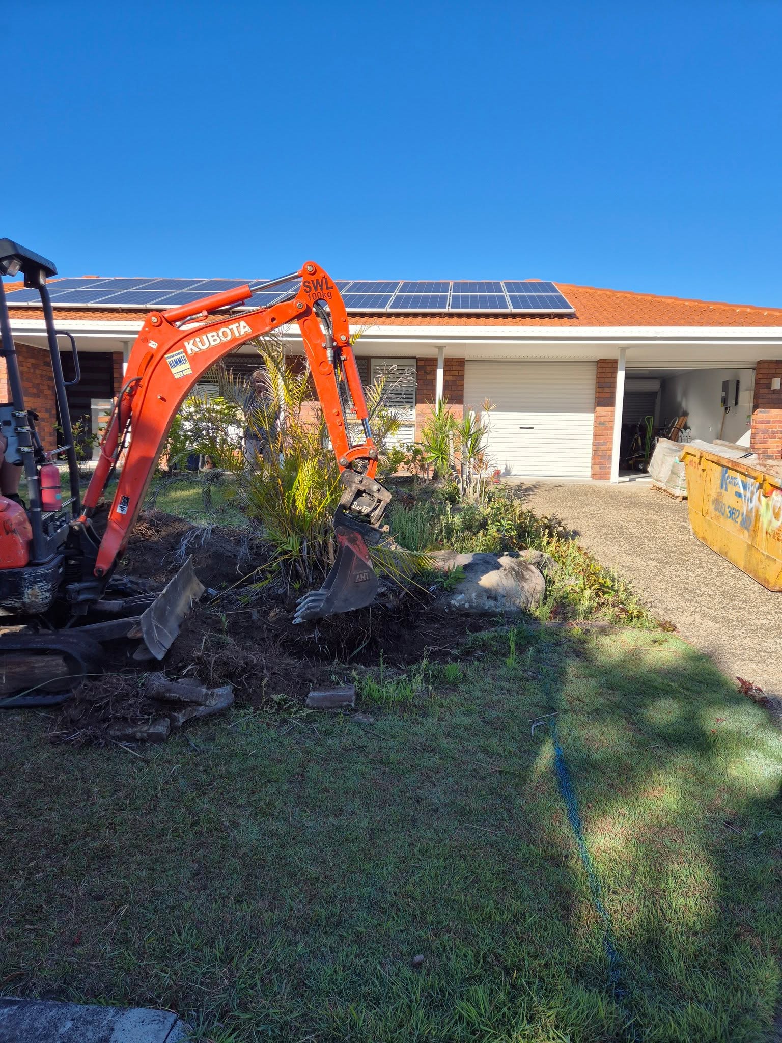 Kubota mini excavator digging a front garden